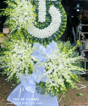 Kệ hoa chia buồn vòng tròn chữ Thọ hoa lan trắng tông trắng xanh trang nghiêm, thiết kế sang trọng phù hợp viếng tang lễ