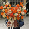 Giỏ hoa tông cam nổi bật với hoa hồng cam, ranunculus, cúc mẫu đơn và hoa phụ cao cấp, thiết kế sang trọng, thích hợp tặng sinh nhật, khai trương, chúc mừng, giỏ hoa tươi cao cấp tông cam ấm áp